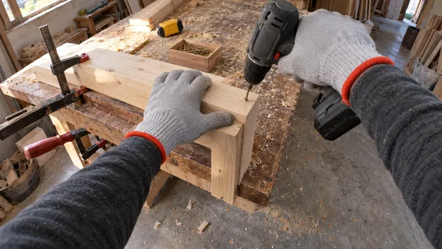 Cámara 3: una mano sujeta una tabla de pino mientras la otra atornilla con un taladro.